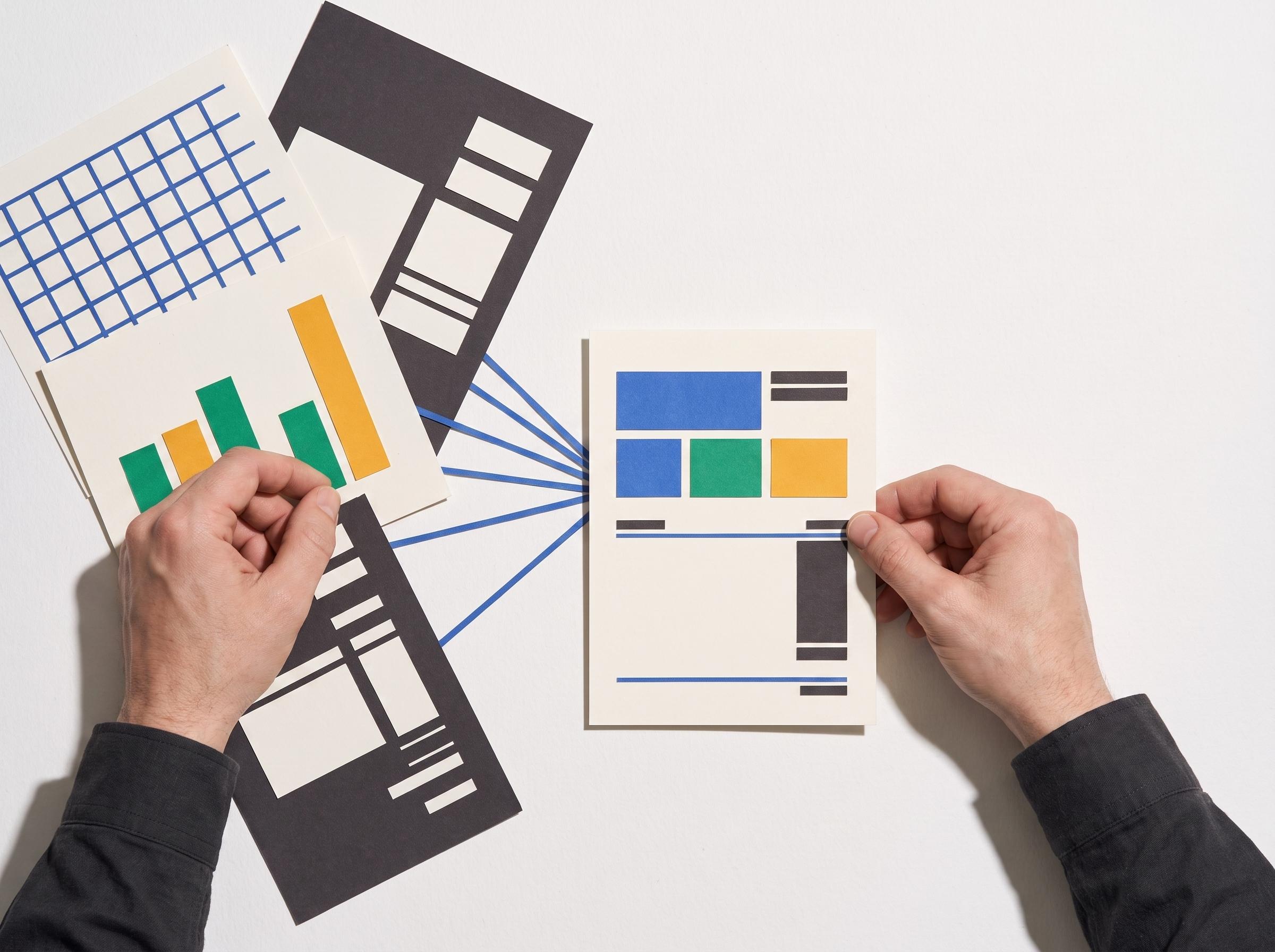 Hands bring information from several wordless workplace documents into one summary report.